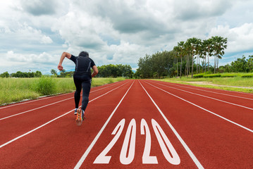 The start into the new year 2020. Start up of runner man running on race track go to Goal of Success.  People running as part of Number 2020.  Holiday sport Concept