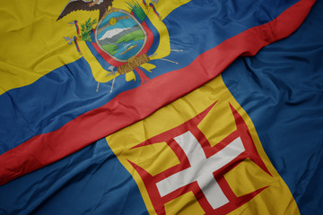waving colorful flag of madeira and national flag of ecuador.