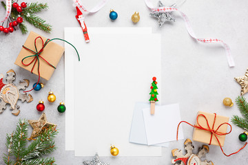 Christmas background with gift boxes, festive decor, fir tree branches and paper cards notes. Flat lay.