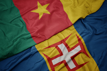 waving colorful flag of madeira and national flag of cameroon.
