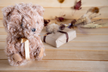 Gift and teddy bear on a wooden background. Autumn background with gifts. Cute gifts on a wooden background. Warm autumn background.
