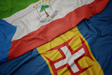waving colorful flag of madeira and national flag of equatorial guinea.