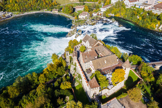 Red roofs and towers of cliff-top Schloss Laufen castle, Laufen-Uhwiesen. Rhine Falls or Rheinfall, Switzerland. Bridge and border between the cantons Schaffhausen and Z&uuml;rich. Panoramic aerial view