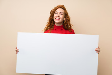 Redhead woman with turtleneck sweater holding an empty white placard for insert a concept