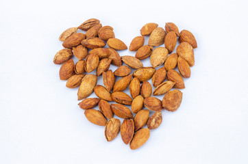 Almond nuts forming a heart-shape isolated on white