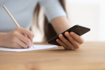 Fototapeta premium Closeup image schoolgirl writing helpful info use online app websites