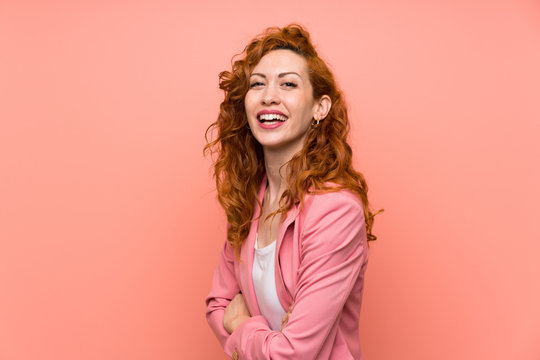 Redhead Woman In Suit Over Isolated Pink Wall Laughing