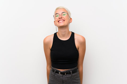Teenager girl with short hair over white wall with glasses and happy
