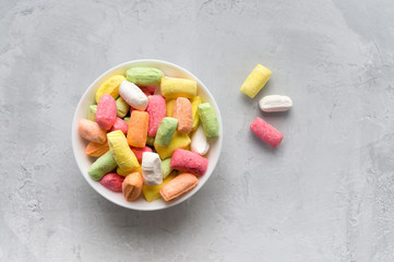 Colored sweet caramel candy on concrete background. Top view.