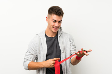 Sport man over isolated white wall in boxing bandages