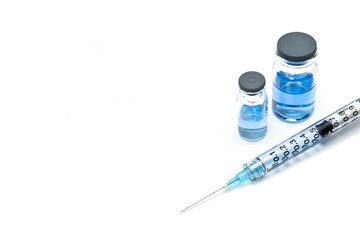 Treatment for rare diseases, virus diseases. A syringe and medicine vials containing blue liquid medicine on the white background