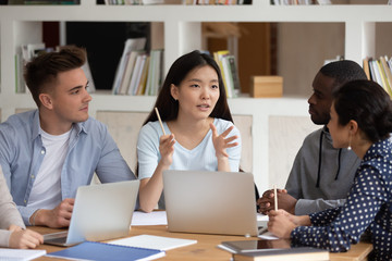 Multiracial students working on common project thinking studying together