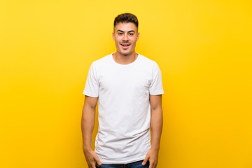 Young handsome man over isolated yellow background with surprise facial expression