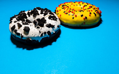 Perspective shot of donuts or doughnuts with white and yellow frosting and decorated with crumbled...