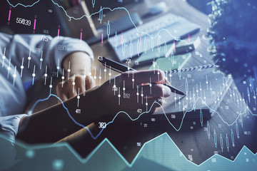 Financial forex charts displayed on woman's hand taking notes background. Concept of research. Double exposure