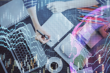 Financial chart drawn over hands taking notes background. Concept of research. Double exposure
