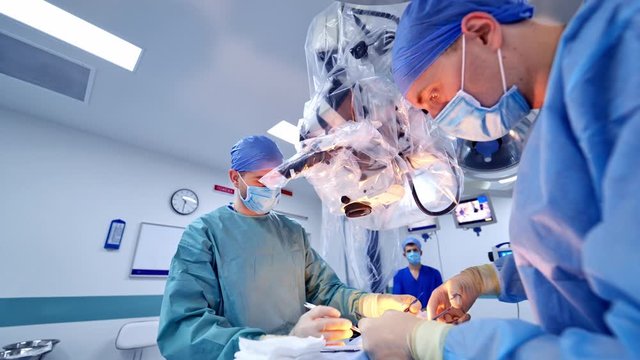 Neurosurgery team operating in clinic. Medical team of surgeons performing operation in modern operating room.
