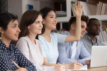 Asian schoolgirl raise hand want to answer or ask question