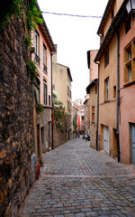 Fototapeta na wymiar Lione. Narrow old town street. French style. France. Autumn in Lione.Old european architecture. Travelling in Europe. Old town buildings. City center. Stone walls