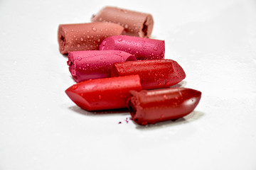 Lipstick broken into pieces, put on a white background.