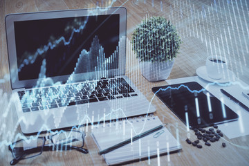 Forex market graph hologram and personal computer on background. Multi exposure. Concept of investment.