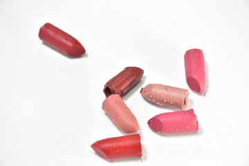 Lipstick broken into pieces, put on a white background.