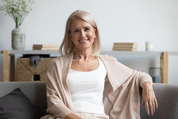 Happy middle aged woman looking at camera at home