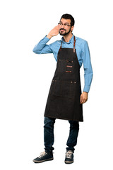 Full-length shot of Man with apron listening to something by putting hand on the ear over isolated white background