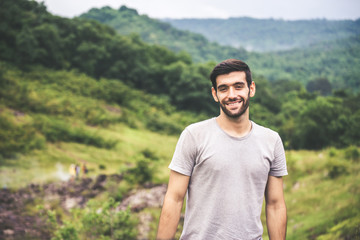Portrait of young handsome man with beard standing at outdoor,Happy and smiling,Travelling concept