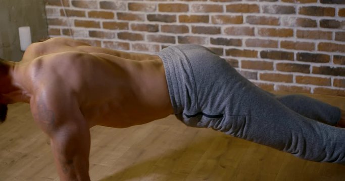 bald yoga instructor changes asanas close view slow motion