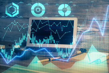 Double exposure of chart and financial info and work space with computer background. Concept of...