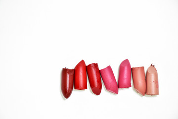 Lipstick broken into pieces, put on a white background.