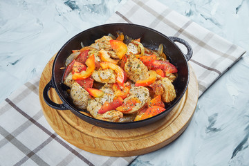 Meat chicken pan with tomatoes and peppers and fried onions. Gray bakcground.