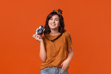 Obraz premium Happy brunette woman is happy to shoot with her camera.