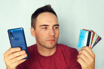 Near Field Communication. Hand holding banknotes credit cards and phone. selecting the smartphone as a method of purchase and payment for merchandise.