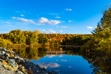 autumn landscape with blue sky and a small lake