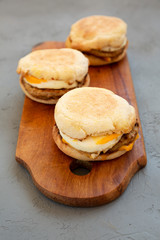 Homemade pork roll egg sandwich on a rustic wooden board on a gray background, side view. Closeup.