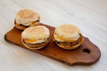 Homemade pork roll egg sandwich on a rustic wooden board on a white wooden background, low angle view. Closeup.