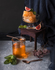 Honey in a jar and honey in a honeycomb on a dark background
