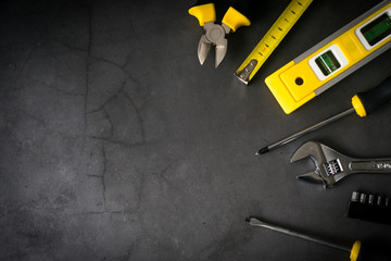 set of tools on one side on concrete black background with empty space