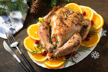 Traditional festive food for Christmas. Christmas turkey stuffed with rice and vegetables on wooden table.