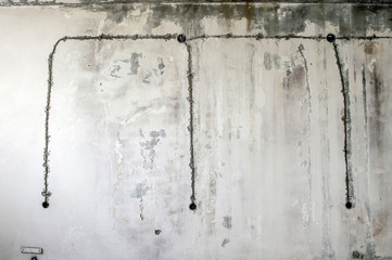 White concrete wall of an old building with an old wiring diagram of electrical outlets. Background