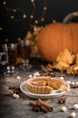 Yellow pumpkin pie orange  pumpkins with yelllow dry autumn leaves decor on dark table background.Harvesting,autumn and Thanksgiving concept