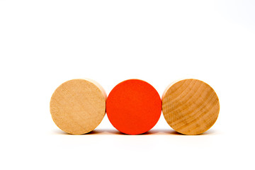 two natural and one red round wooden toy blocks isolated on white background