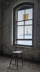 Fototapeta na wymiar Statue of Liberty through the window of Ellis Island Hospital