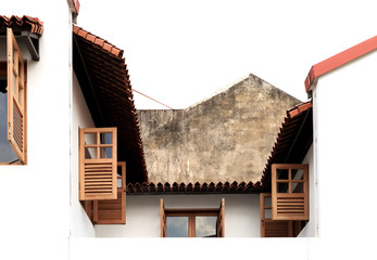 Traditional vintage shop house windows with antique shutters on a white wall view