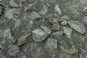 Background of stones on the black ground of Lava of a Etna Volcano