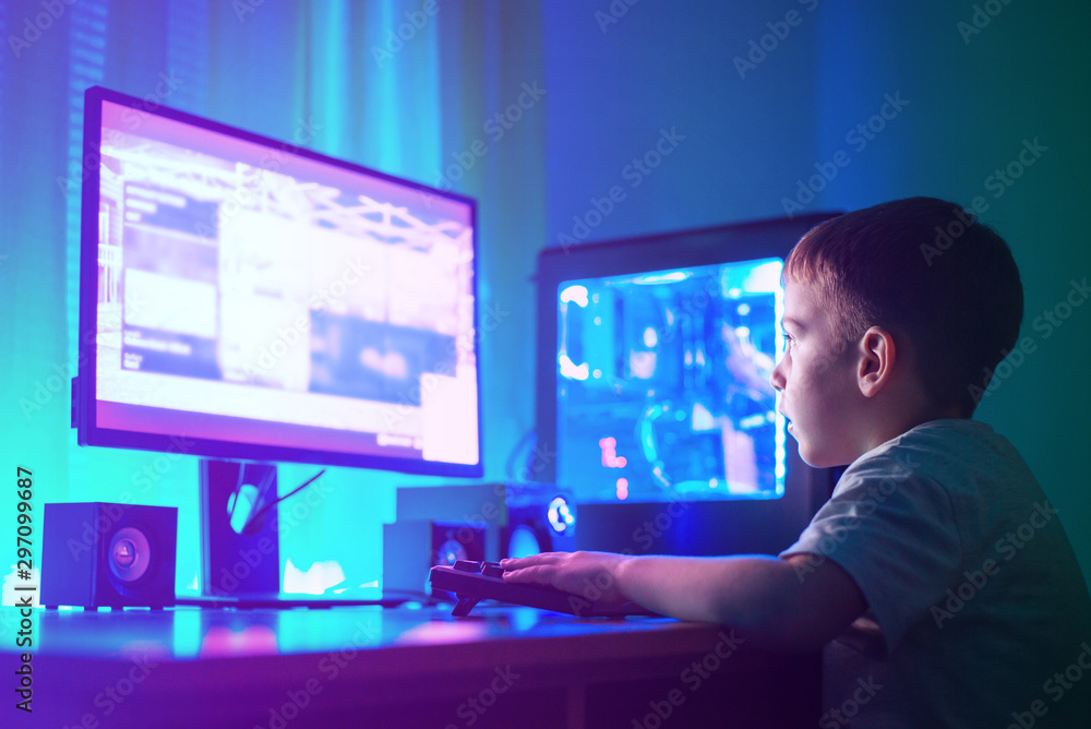 Poster Boy play game on gaming computer or hacking a website concept. Dark scene with lots of RGB lighting.