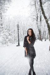 Fototapeta na wymiar Girl in dress in winter snow covered park