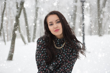 Girl in dress in winter snow covered park